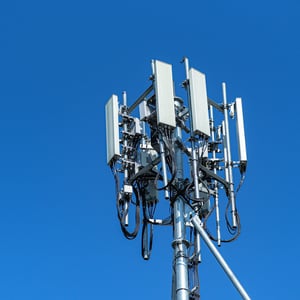 A telecommunications tower equipped with multiple antennas, including a specialized 5G antenna, enabling wireless communication.