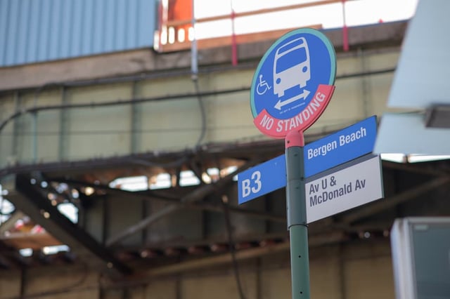 A B3 bus stop sign for Bergen Beach at Avenue U and McDonald Avenue in front of an elevated subway track.