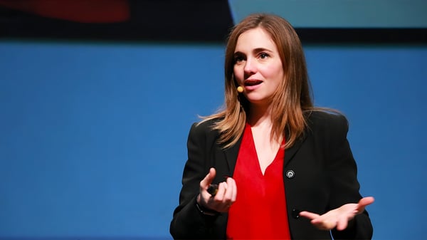Alicia Asín, Co-Founder of Libelium, speaking on stage with a headset microphone and handheld remote.