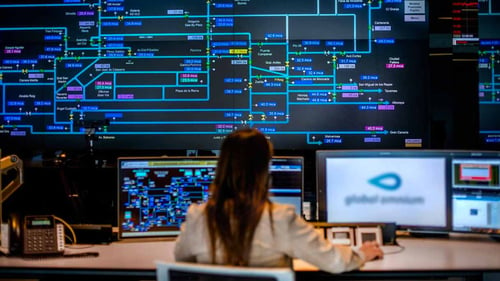 A women sitting on a desk working on a computer in a smart water utility supervision center