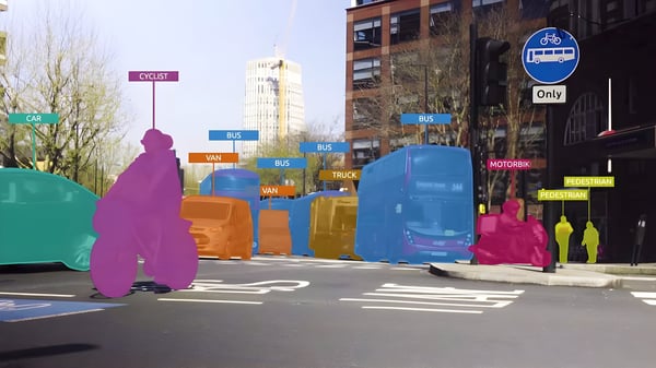 AI computer vision overlay identifying buses, cars, and cyclists with colorful bounding boxes on a busy Sheffield street.