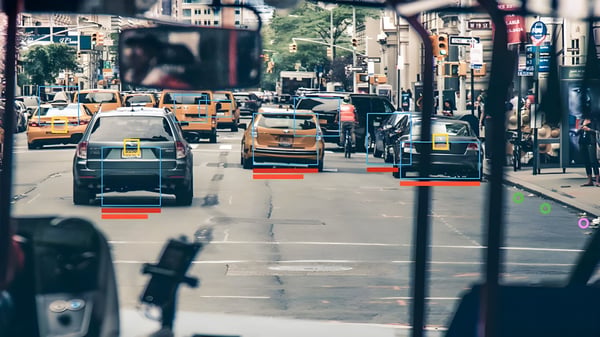 Computer vision interface tracking vehicles with digital bounding boxes on a busy New York City street.