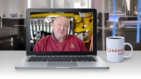 Bret Hodne on a laptop screen next to a Kurrant Insights coffee mug on a white desk.