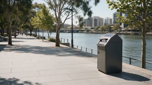 A Superfy solar-powered smart bin on a paved waterfront promenade with a river, trees, and city buildings in the background.