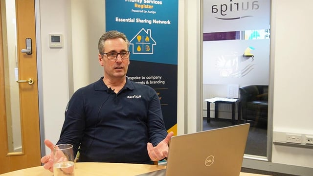 Portrait photo of David Woakes, Client Solutions Director at Auriga on a desk with a laptop.