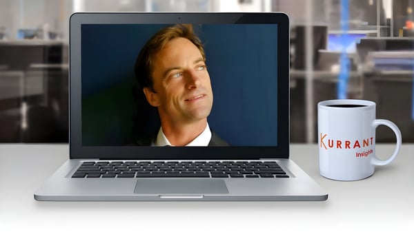 David Bruemmer on a laptop screen next to a Kurrant Insights coffee mug in an office setting.