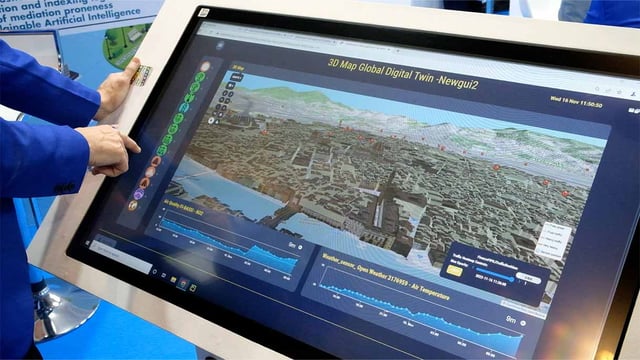 A man working on a large touch screen displaying a representation of a city digital twin
