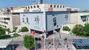 Aerial view of the DEWA headquarters building in Dubai featuring large banners of UAE leaders and national flags