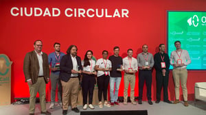 Ten people holding awards stand on a stage in front of a red wall with "CIUDAD CIRCULAR" text.