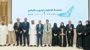 A group of officials stands in front of a screen displaying the UAE Pollen Atlas logo at a launch event.