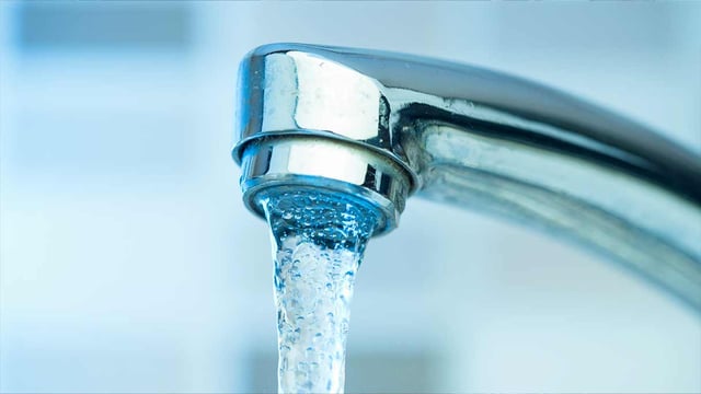 Image of water flowing from a tap being delivered from a smart water utility using IoT.