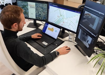 A man using a computer in the control room of the city of reims working on an IoT Platform.