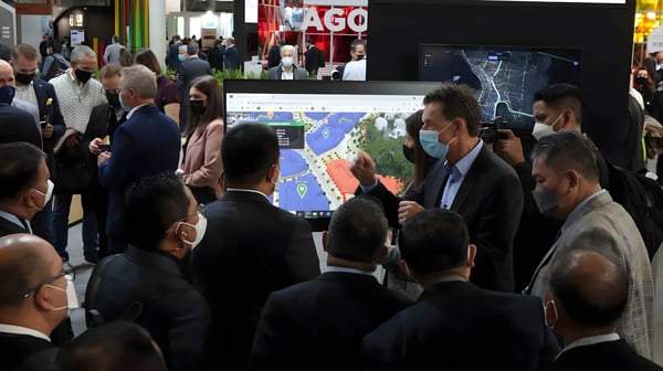 Attendees in masks gather around a digital map display at the Smart City Expo World Congress Barcelona 2021.