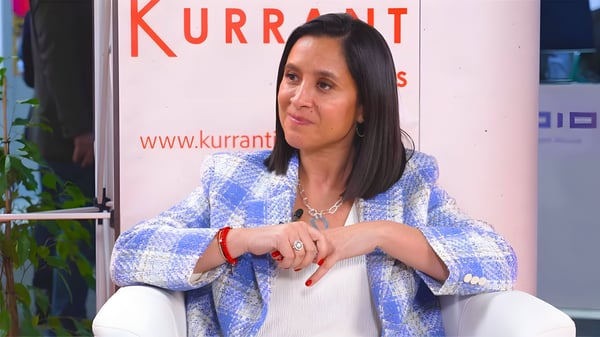 Woman in a blue and white checkered blazer seated in front of a Kurrant Insights banner.
