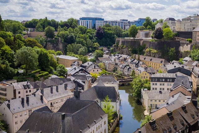 High-angle view of the Grund district in Luxembourg City featuring historic stone buildings along the Alzette River.