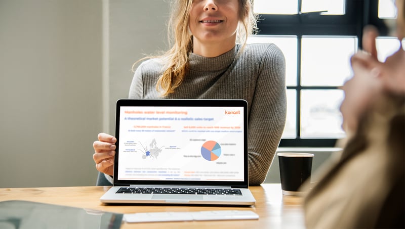 A woman analyzing a graph on her laptop, conducting a market study.