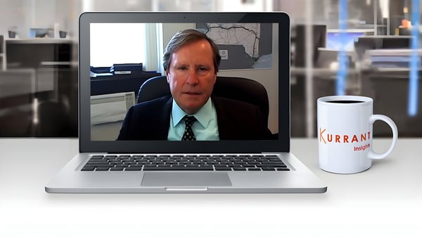 Matthew Driscoll on a laptop screen during a video call next to a Kurrant Insights coffee mug on a desk.