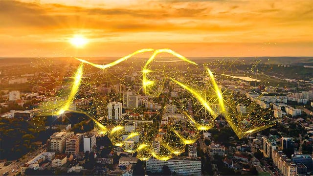 A smart city in the backgorund with handshake made out of light in the foreground
