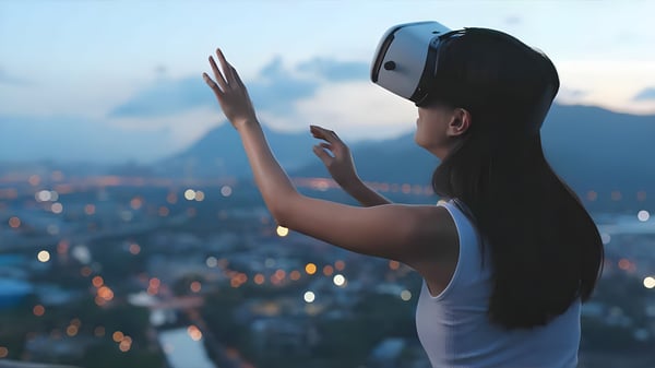 Woman wearing a VR headset and reaching out with her hands overlooking a blurred city skyline at dusk.