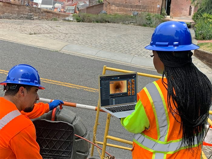 Technicians conducting a sewer inspection powered by AI