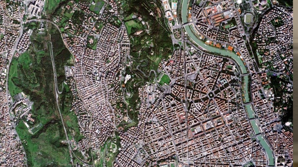 Satellite view of Rome showing the Tiber River, urban streets, buildings, and green spaces from above