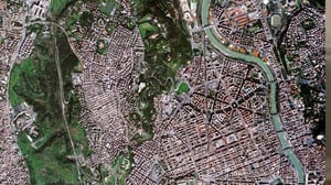Satellite view of Rome showing the Tiber River, urban streets, buildings, and green spaces from above