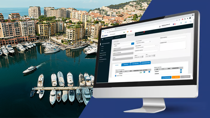 Computer monitor displaying a software dashboard next to an aerial view of a coastal city marina with yachts - R-smart