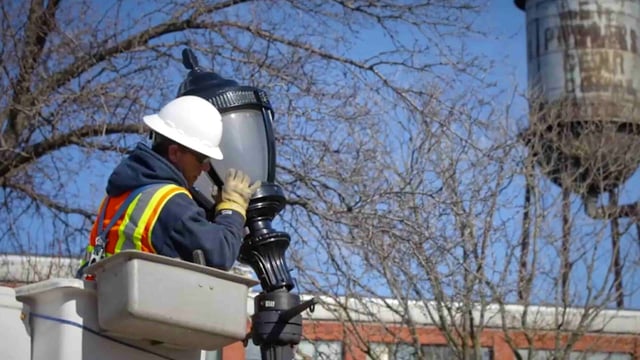A technician in New York City upgrading a Luminaire to a Smart Street Light LED one.