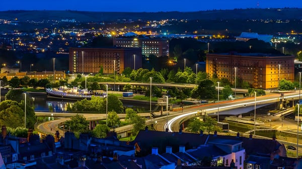 Elevated night view of illuminated city streets, bridges, and buildings in Stockholm with glowing street lights.