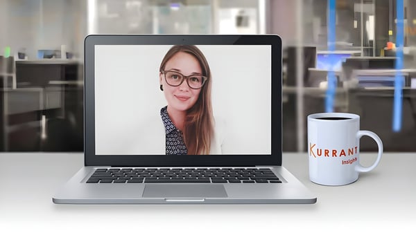 Sylvia Haack on a laptop screen next to a Kurrant Insights branded coffee mug in an office setting.