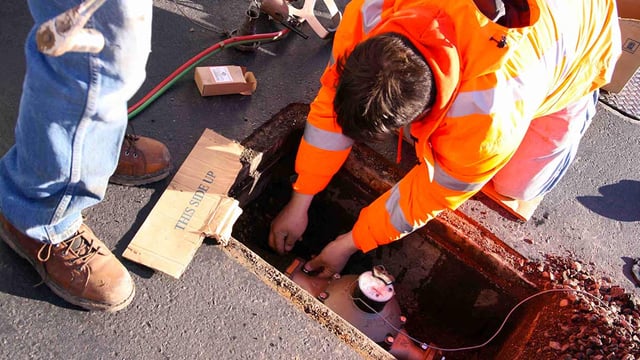 A water utility technician installing an AMI smart water meter in a smart city