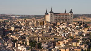 Panoramic view of the historic quarter of Toledo, Spain, featuring the Alcázar stone fortification and dense urban housing.