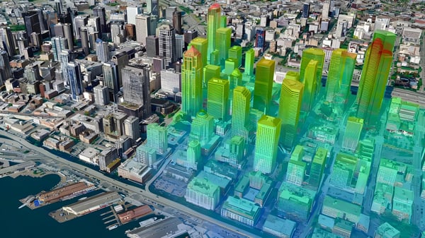 3D digital twin visualization of a city skyline with buildings highlighted by a green and orange heat map overlay.