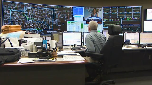 A technician working in the control room of a smart utility