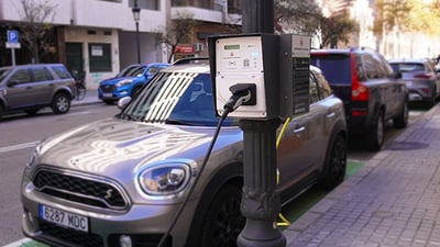 An electric vehicle charging from an EV charger mounted on a smart street light in the city of valencia in spain