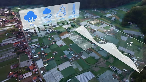 Aerial view of a town with digital overlays showing weather icons, data charts, and wind turbine graphics.