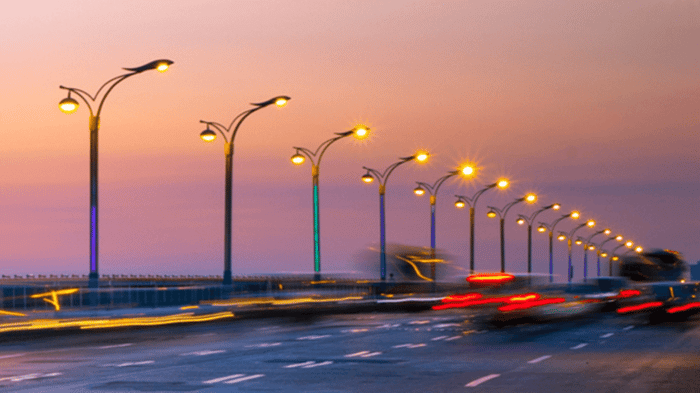 A road stretching into the distance, lined with traffic lights and street lights, guiding vehicles along their way