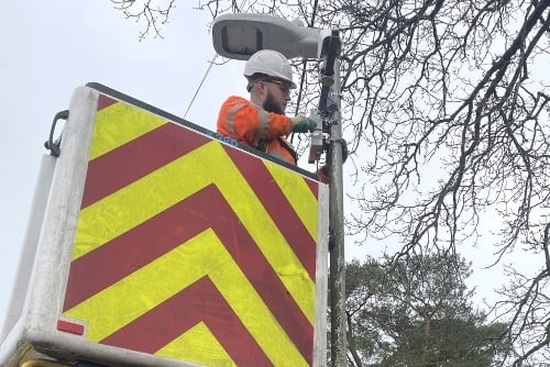 Engineer installing a themral IoT sensor on a Smart Street Lighting Pole