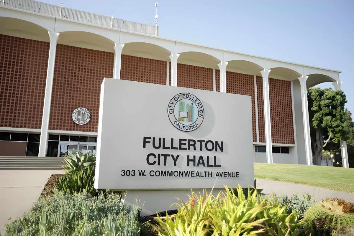Fullerton City Hall monument sign in front of a mid-century modern brick building with white arches.