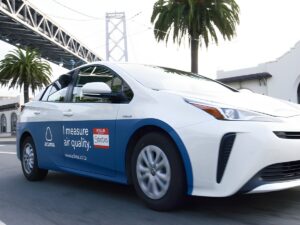 Aclima air quality monitoring vehicle driving on a city street near the San Francisco-Oakland Bay Bridge.