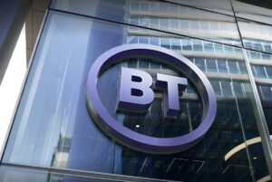 A purple BT logo mounted on the glass exterior of a modern office building.