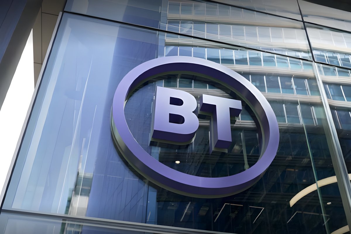 A purple BT logo mounted on the glass exterior of a modern office building.