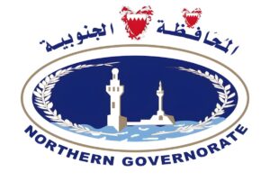 Official logo of the Northern Governorate of Bahrain featuring white towers and Arabic script on a blue oval background.