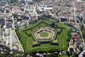 Aerial view of the pentagonal Citadel of Jaca surrounded by green moats and the dense urban buildings of Jaca, Spain.