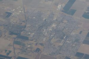 High-altitude aerial view of Lemoore, California, showing residential grids surrounded by agricultural fields.