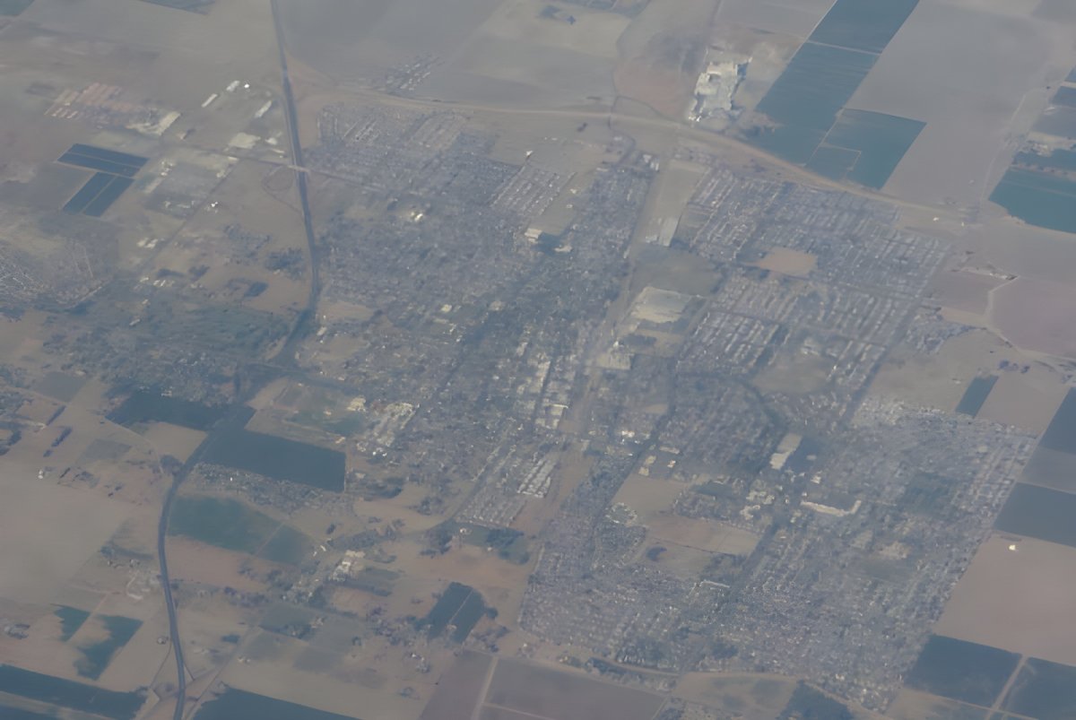 High-altitude aerial view of Lemoore, California, showing residential grids surrounded by agricultural fields.