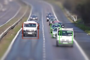 AI computer vision bounding boxes identifying cars and vans driving on a multi-lane highway.