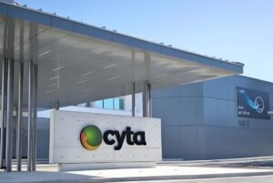 Cyta company logo on a concrete monument sign in front of a modern office building with a large metal canopy.