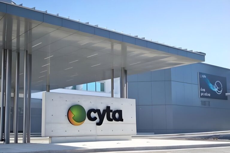 Cyta company logo on a concrete monument sign in front of a modern office building with a large metal canopy.