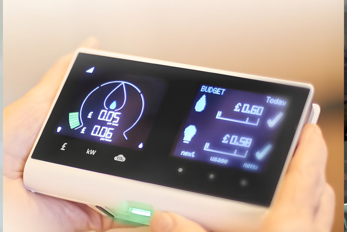 A person holding a digital smart meter in-home display showing real-time energy usage and costs in British pounds.